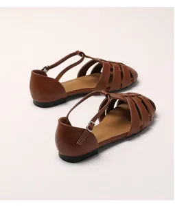 Détail de sandales pêcheur en cuir marron avec design tressé et boucle en métal argent