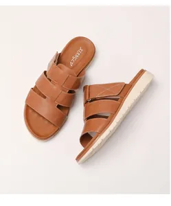 Détail de sandales compensées en cuir marron avec trois brides et semelle blanche épaisse
