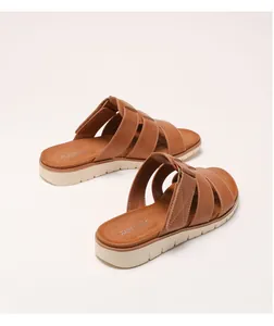 Détail de sandales compensées en cuir marron avec brides croisées et semelle plateforme