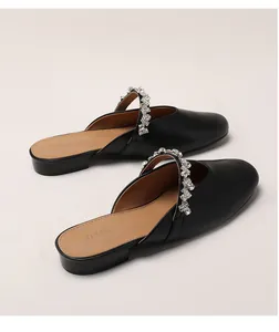Detail of black pointed-toe mule shoe featuring elegant rhinestone encrusted strap design