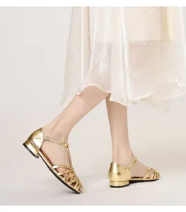 Detailed view of golden metallic woven caged sandals with T-strap and buckle closure
