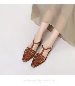 Brown woven flat fisherman sandals on model with vintage French retro hollow design