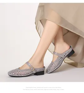 Détail de mules grises en maille avec strass et bride réglable portées au pied