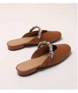 Close-up of tan pointed-toe mule with rhinestone strap and low block heel detail