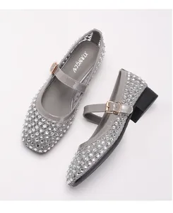 Details grauer Mesh-Mary-Janes mit silbernen Strasssteinen und glänzenden Lackriemen