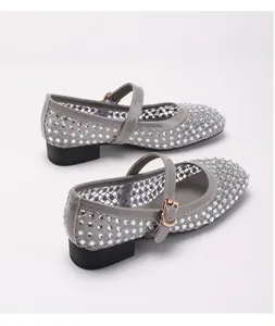 Detail der grauen Mesh-Mary-Jane-Schuhe mit funkelnden Strasssteinen und goldener Schnalle