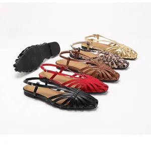 Detail van geweven holle bandjes op retro platte sandalen in meerdere kleuren