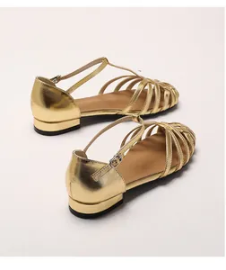 Close-up of golden woven hollow-out leather sandals with adjustable T-strap buckle