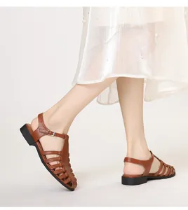 Detailed close-up of brown woven leather sandals with adjustable ankle buckle strap