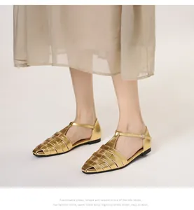 Detail van gouden geweven sandalen met verstelbare T-band en metallic lederen afwerking