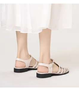 Detail view of woven cage style gladiator sandals with metal buckles and flat soles