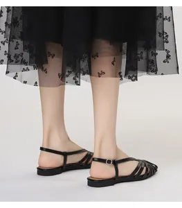 Detail van zwarte sleehak sandalen met verstelbare zilveren gesp bij de enkel