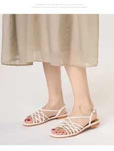 Detail of hand-woven cream gladiator sandals with thin straps and adjustable buckle