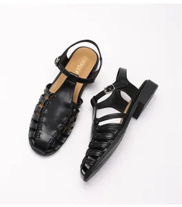Detail of black woven cage sandals with adjustable ankle strap and flat leather sole