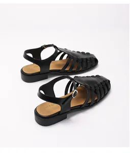 Detail of black woven leather fisherman sandals with adjustable silver buckle strap