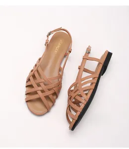 Detail of brown Roman woven leather straps and adjustable gold ankle buckle closure