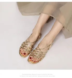 Detailed close-up of handmade gold braided flat Roman sandals with metallic straps