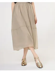 Detail eines eleganten khakifarbenen Midi-Faltenrocks mit elastischem Bund und Tüllstoff