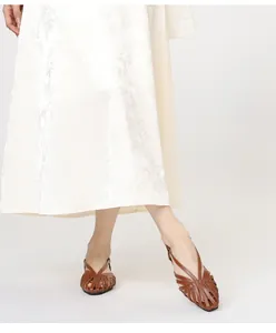Detail van bruine gevlochten leren sandalen met een vintage vierkante teen ontwerp