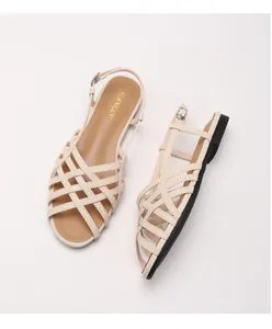 Detail of apricot woven cage flat sandals with silver buckle and cross straps