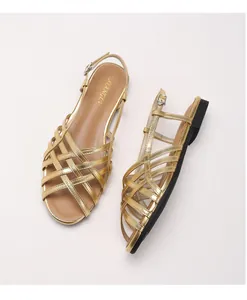 Top view of gold woven gladiator sandals with cross-strap design and adjustable buckle