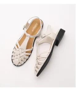 Detailansicht der geflochtenen cremefarbenen Riemen an Vintage Blockabsatz Sandalen