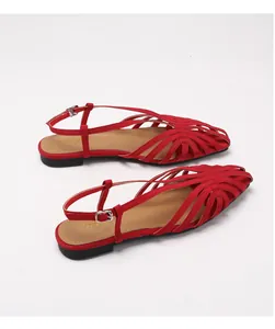 Detail van rode geweven sandalen met dichte neus, verstelbare gesp en zachte zool
