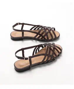 Detailed top view of dark brown woven flat Roman sandals with delicate buckled straps