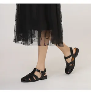 Seitenansicht schwarzer geflochtener Römersandalen kombiniert mit einem Vintage-Kleid