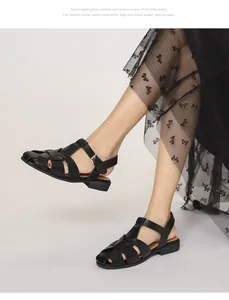 Detailansicht der schwarzen geflochtenen Römersandalen mit Fesselriemen und Goldschnalle