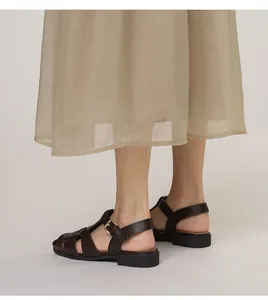 Details von dunkelbraunen gewebten Römersandalen aus Leder mit Metallschnalle