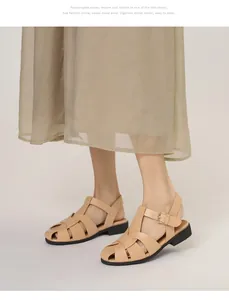 Detail der vintage geflochtenen beigen Sandalen mit Schnallenriemen und rundem Zehenbereich