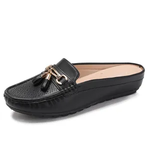 Mules da donna in finta pelle nera con fibbia dorata e dettagli di frange alla moda