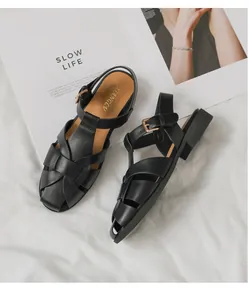 Detailansicht schwarzer geflochtener Leder-Fischersandalen mit goldener Schnalle