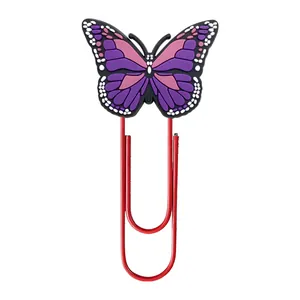 Close-up of a large red metal paperclip featuring a colorful PVC butterfly ornament