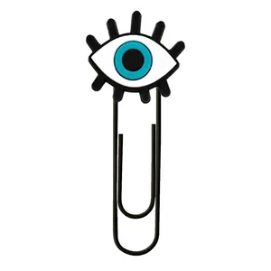 Close-up of black paperclip with evil eye decorative charm and long U-shaped metal structure