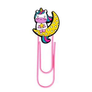 Pink metal paper clip with a cute PVC unicorn sitting on a yellow crescent moon bookmark