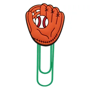 Close-up of green metal paperclip with orange PVC baseball glove and ball decorative top