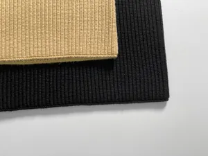 Close-up of rib-knit fabric detail in beige and black showing premium textile texture