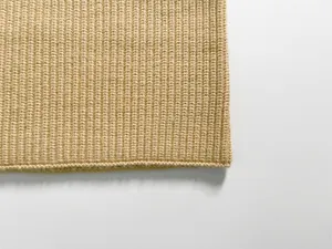 Macro shot of the beige rib-knit texture and soft stitching details of this warm winter scarf