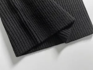 Close-up of black ribbed knit fabric texture on warm winter neck warmer scarf