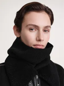Detail of black ribbed knit winter neck warmer with plush trim and soft wool texture