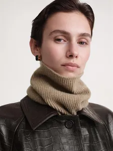 Detailed close-up of khaki ribbed knit collar and minimalist black and gold rectangle earrings