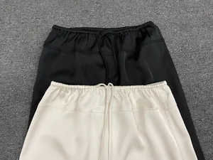 Detail of satin drawstring waistbands on black and beige A-line maxi skirts