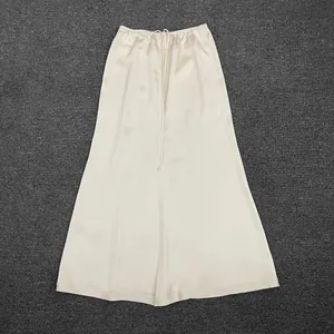 Detail of champagne satin midi skirt showing drawstring elastic waist and silky texture