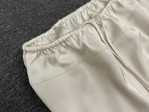 Detail view of the cream satin skirt showing elastic waistband with matching drawstring
