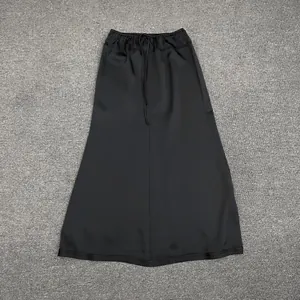 Detailed view of black satin A-line maxi skirt with elastic drawstring waist and silk texture