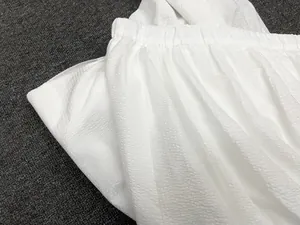 Detailed macro view of white seersucker fishtail skirt with elastic pleated waistline