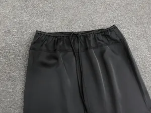 Detail of elastic waist with drawstring on black satin long skirt showing smooth texture