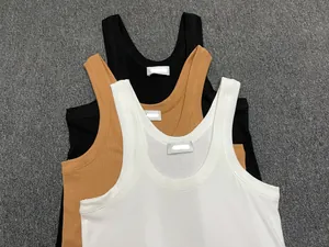 Close-up of ribbed cotton tank tops in black, camel, and white with elastic texture